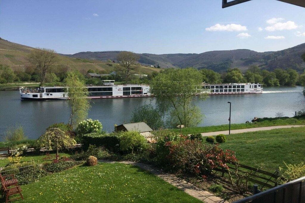 Une rivière où l’on peut naviguer, bordée de verdure et entourée de collines.