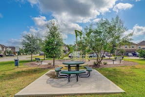 A park with picnic tables and benches, surrounded by trees and a playground. - Near Highways & Hospitals! Extended Stay in Katy (Katy)