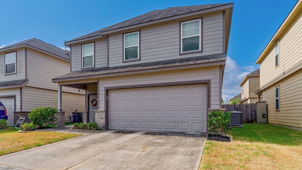 A two-story residential building with a garage, a front porch, and a brick foundation. - Near Highways & Hospitals! Extended Stay in Katy (Katy)