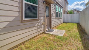 A residential house with a front yard, a wooden fence, and a door with a doormat. - Near Highways & Hospitals! Extended Stay in Katy (Katy)