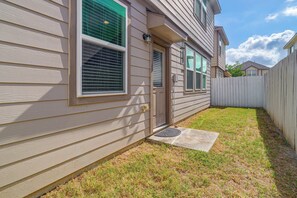 A residential house with a front yard, a wooden fence, and a door with a doormat. - Near Highways & Hospitals! Extended Stay in Katy (Katy)