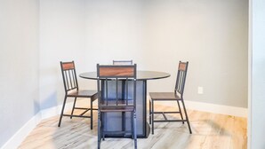 A dining area with a round table and four chairs, featuring a modern design with metal frames and wooden seats. - West Oak House - Bright 3-Bedroom Single-Family Home in Wylie (Wylie)