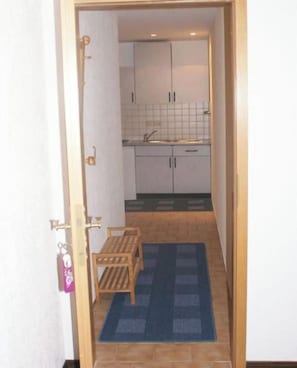 A narrow hallway leading to a kitchen with cabinets and a sink. - Holiday apartment with 1 bedroom (Masserberg OT Fehrenbach)