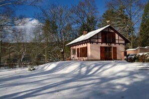 A traditional chalet with a pitched roof, wooden exterior, and a front porch. - Holiday home with 2 bedrooms (Leonberg-Warmbronn)