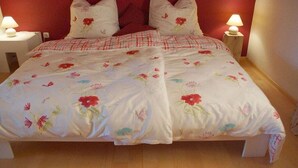 Un lit avec une literie à motifs floraux et deux lampes de chevet.