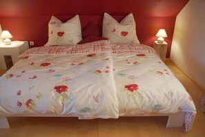 A bed with floral bedding and two bedside lamps. - Panoramic view of the Höllbach valley (Rettenbach)