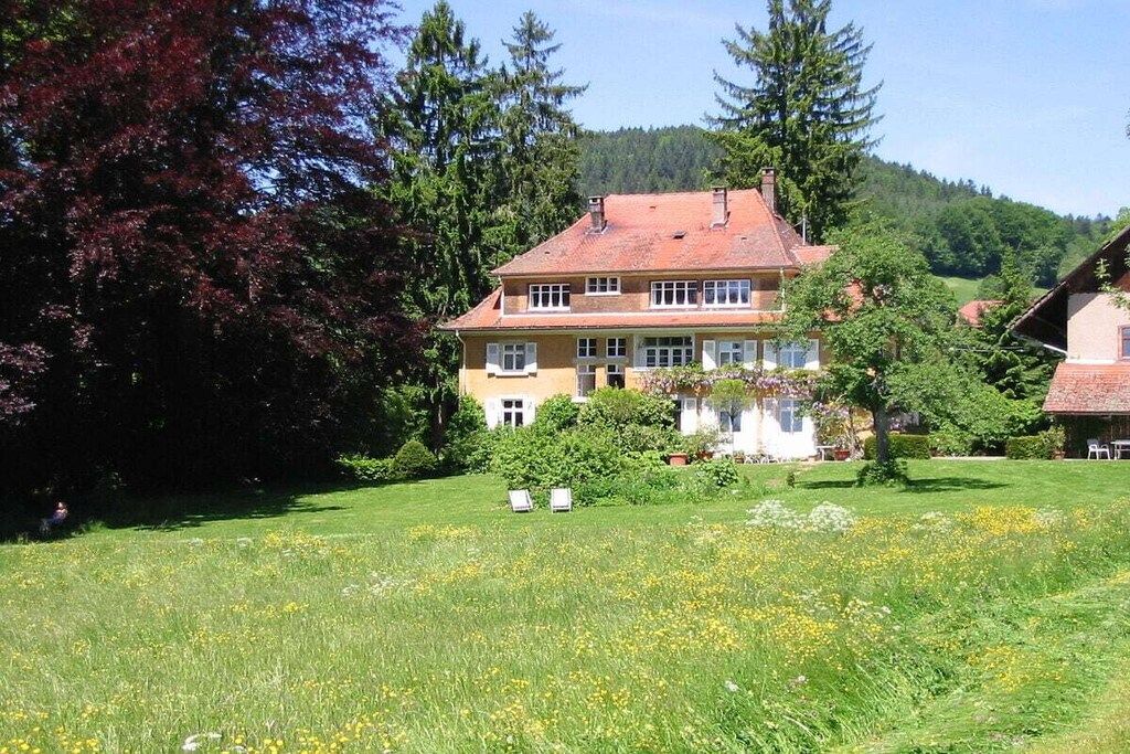 Una casa de dos pisos amb un jardí al davant.