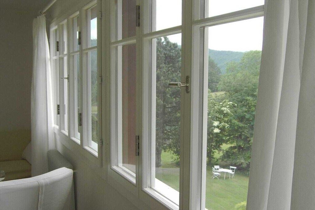 A room with a large window overlooking a garden.