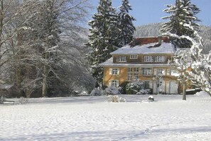 A two-story house with a snow-covered roof and surrounding trees. - 1 Alpenblick - Steineckhof (Schopfheim)
