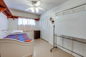 A bedroom with a bed, a ceiling fan, a wardrobe, and a desk. - Bring Your Boat! Waterfront Clearwater Gem w/ Pool (Clearwater)