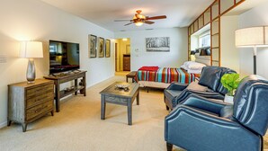 A living room with a television, a coffee table, a sofa, and a ceiling fan. - Bring Your Boat! Waterfront Clearwater Gem w/ Pool (Clearwater)