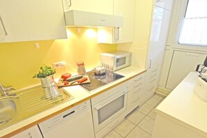 A modern kitchen with a microwave, oven, and a sink.