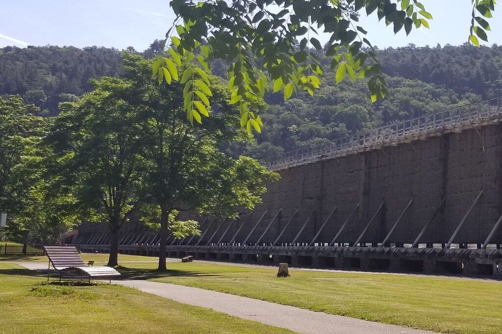 A large, open area with a long, straight wall and a pathway leading to a seating area.