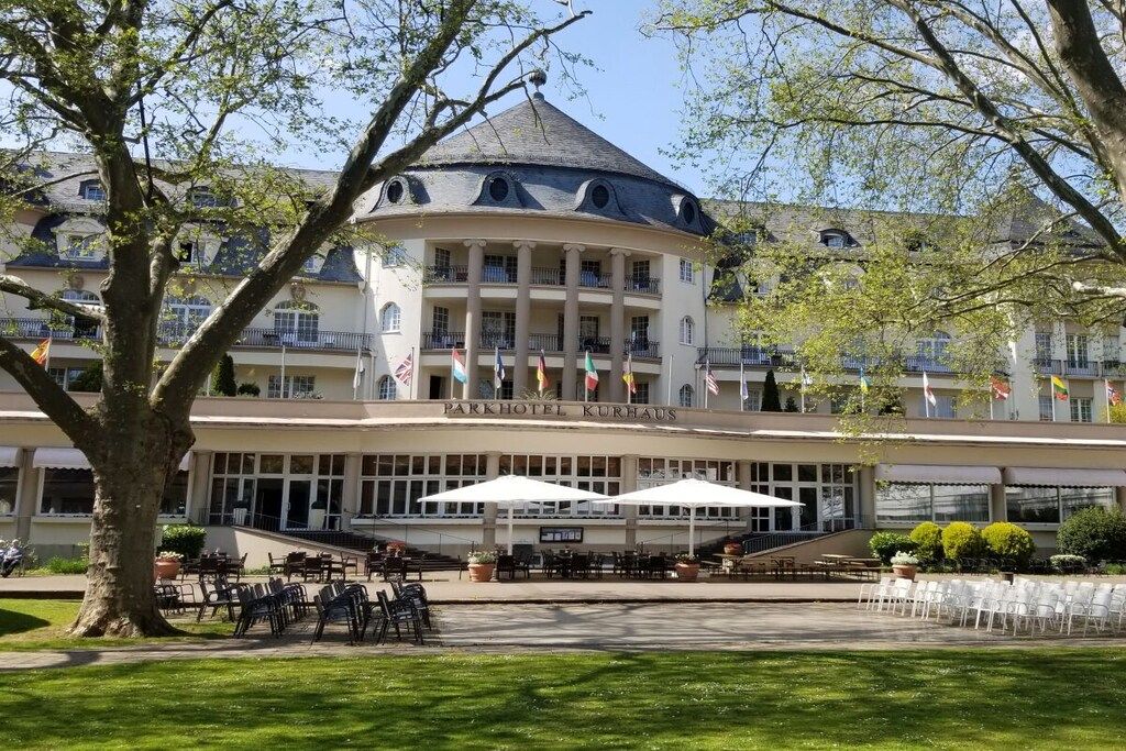 A hotel with a central round building, multiple balconies, and outdoor seating areas.