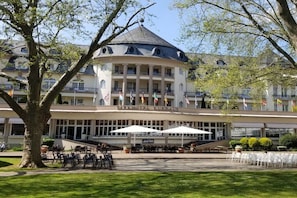 A hotel with a central round building, multiple balconies, and outdoor seating areas. - Holiday apartment with 1 bedroom (Bad Kreuznach)