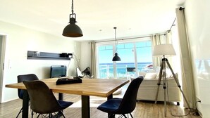 Un comedor con una mesa de madera, cuatro sillas y dos lámparas colgantes.