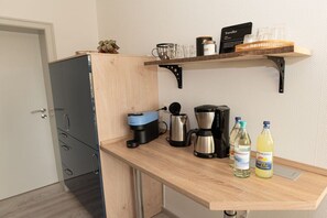 A kitchen with a coffee maker, kettle, and bottles on the counter. - Holiday apartment with 1 bedroom (Bad Harzburg)