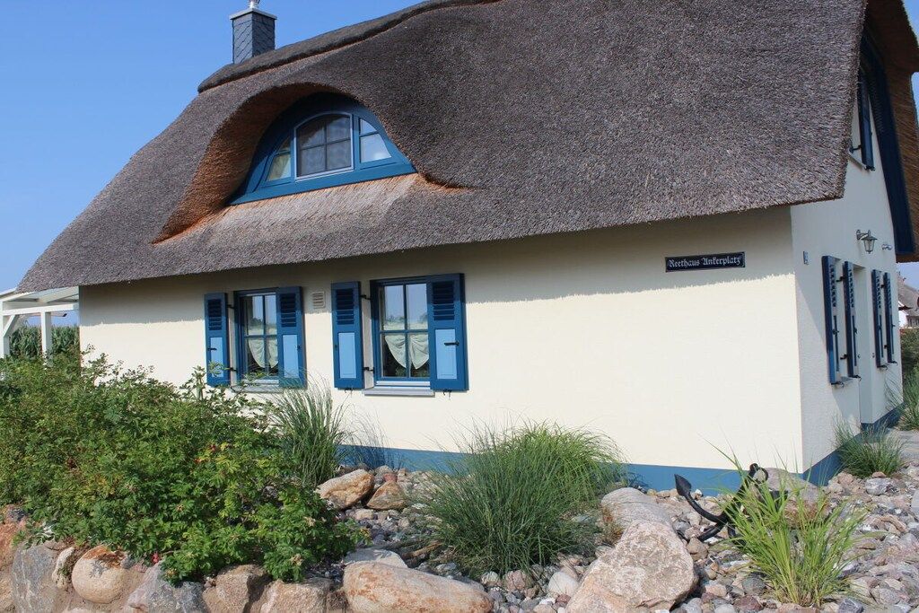A traditional thatched-roof house with a sign indicating 'Nettohaus Interplatz'.