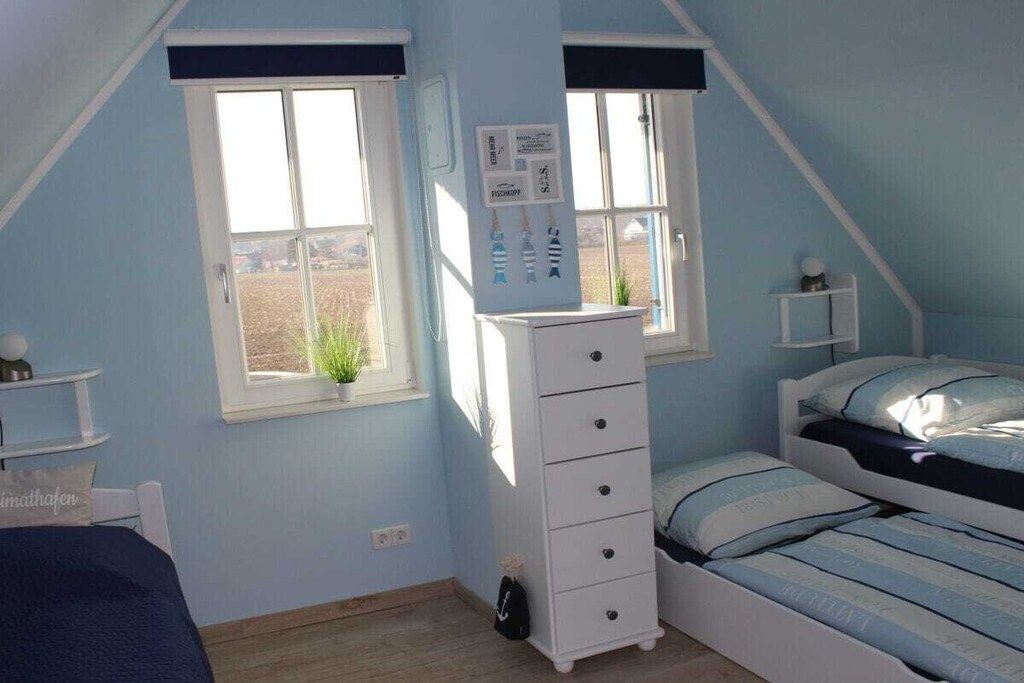 Un dormitorio con una cama litera, un aparador y una ventana con vistas al exterior.