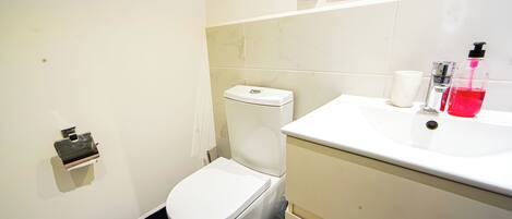 A modern bathroom with a toilet, sink, and mirror.