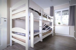 A bunk bed room with a window and a radiator. - Holiday apartment with 2 bedrooms (Carolinensiel)