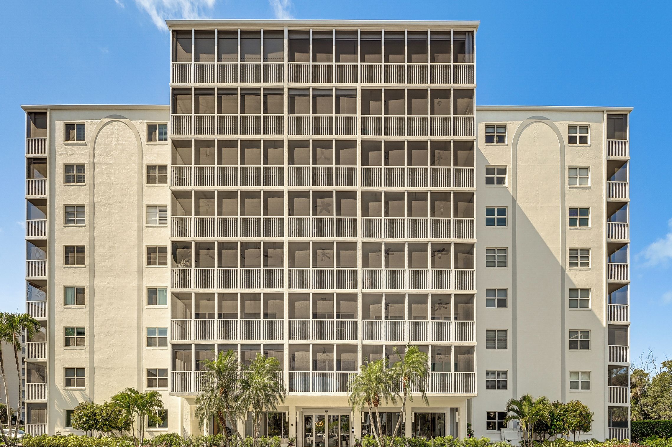 A multi-story hotel with a grid of balconies and large windows.