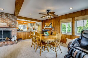 A dining area with a wooden table, chairs, and a fireplace. - Ortonville Lakefront: Hot Tub & Casino Room (Ortonville)