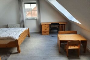 Ein Schlafzimmer mit einem Bett, einem Schreibtisch und einem Stuhl.