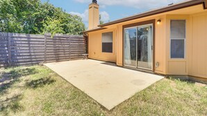 Un edificio residenziale con un portico coperto, una recinzione in legno e un camino.