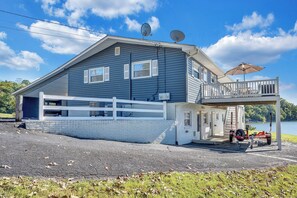 A two-story house with a covered porch, satellite dishes, and a garage.