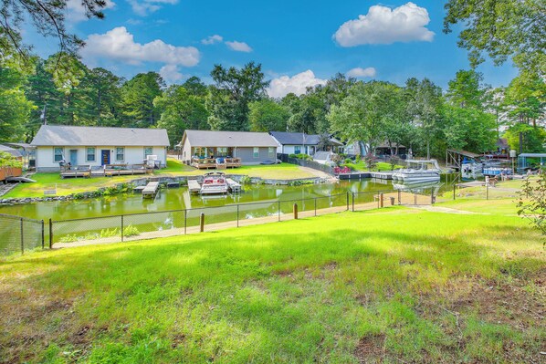 A lakeside property with multiple houses, a dock, and a boat. - Boat Dock & Game Room! Lake Hamilton Home (Hot Springs)