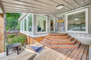 A covered outdoor area with a wooden deck, a seating area, and a view of the surrounding greenery. - Boat Dock & Game Room! Lake Hamilton Home (Hot Springs)