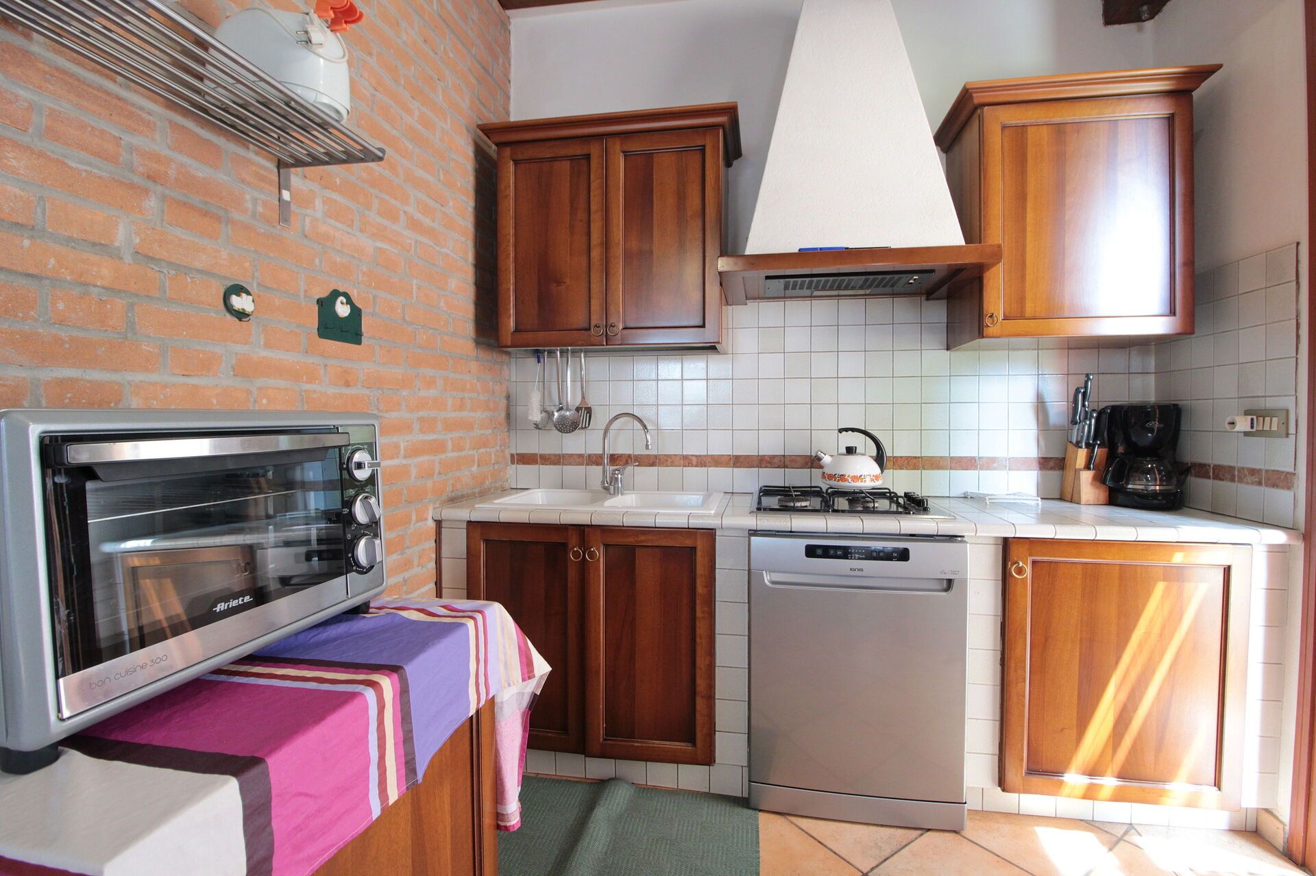 A compact kitchen with a built-in oven, a dishwasher, and a stove.