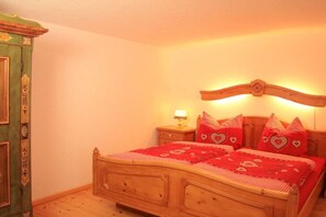A bedroom with a wooden bed, a nightstand with a lamp, and a green wardrobe. - ||---------------------"Haus Waldesruh"------------------|| (Elbingerode)