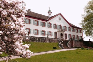A large, white building with red accents and a stone wall foundation. - Holiday apartment with 2 bedrooms (Schliengen)