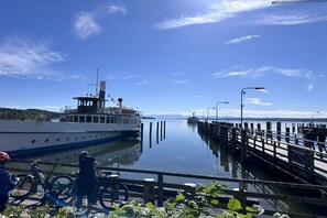 Un endroit paisible au bord de l’eau, avec un quai, un bateau et des vélos.