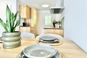 Une cuisine moderne avec des meubles en bois, une cuisinière et une plante.