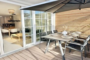Un espace de vie à aire ouverte comprenant un coin repas, des portes-fenêtres coulissantes et un mur en bois.