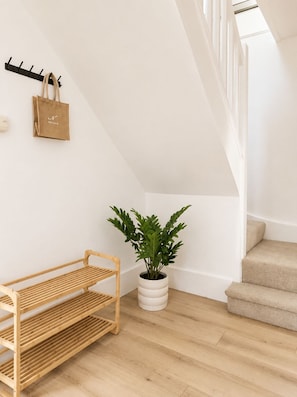 A modern interior with a wooden bench, a potted plant, and a staircase. - Historic Charm in the Heart of Fordingbridge (Fordingbridge)