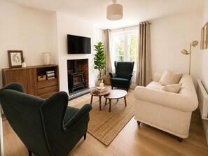A living room with a fireplace, a sofa, two armchairs, a coffee table, and a television. - Historic Charm in the Heart of Fordingbridge (Fordingbridge)
