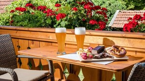Una mesa de madera con dos vasos de cerveza, un plato de pretzels y un libro.