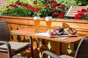 A wooden table with two glasses of beer, a plate of pretzels, and a book. - Holiday apartment with 1 bedroom (Chieming)