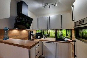 A modern kitchen with a built-in microwave, coffee maker, and a sink. - Holiday apartment with 1 bedroom (Hahnenklee)