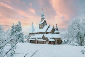 A snow-covered wooden church with multiple spires and a clock tower. - Holiday apartment with 1 bedroom (Hahnenklee)