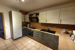 Eine moderne Küche mit einer doppelten Spüle, einem Backofen und Holzschränken.