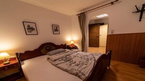 Quarto com cama de madeira, abajures e guarda-roupa de madeira.
