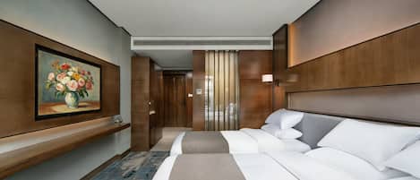 Habitación de hotel con cama, un cuadro, una mesita de noche y vistas al pasillo.