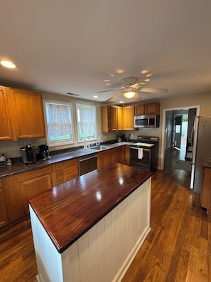 Una cocina moderna con armarios de madera, electrodomésticos de acero inoxidable y una isla central.