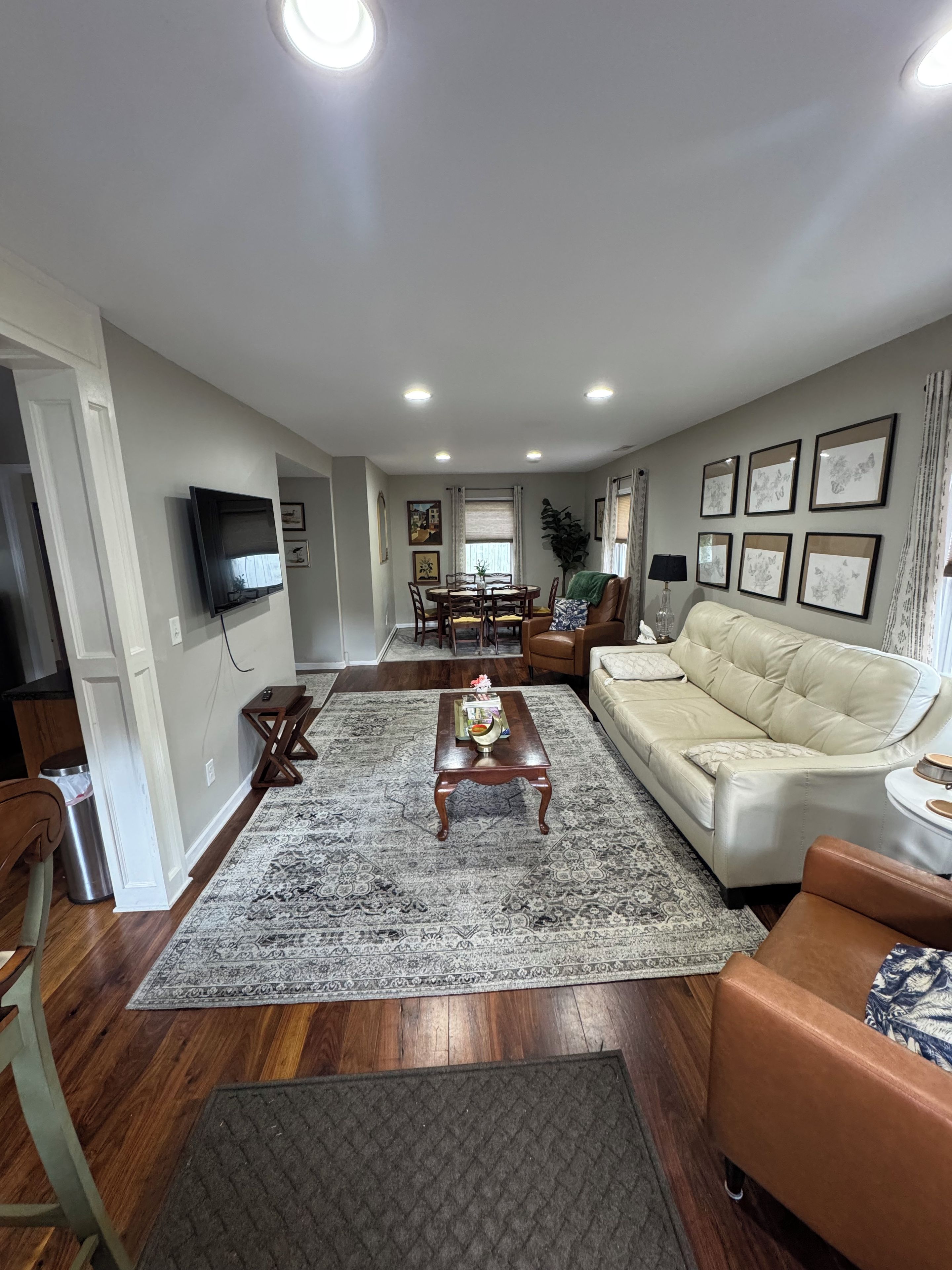 A living room with a sofa, coffee table, and a television mounted on the wall.