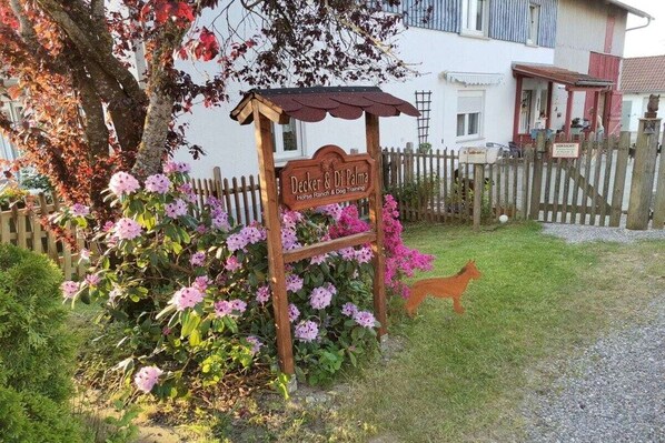 A wooden sign for 'Decker & Di Palma Horse Ranch & Dog Training' with a dog cutout and pink flowers. - Melitta holiday apartment (Heiligenberg)